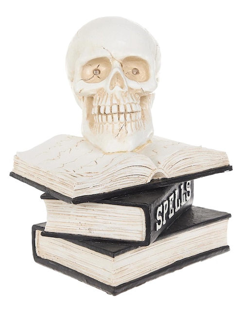 Figura decorativa de halloween con forma de calavera sobre libros