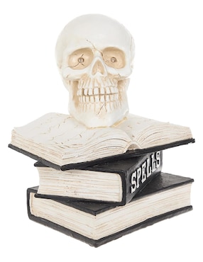Figura decorativa de halloween con forma de calavera sobre libros