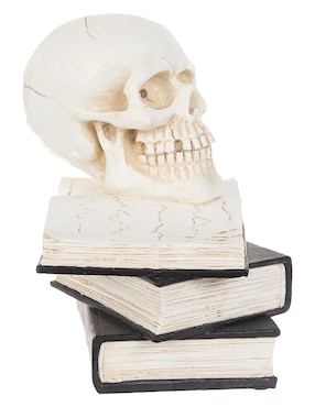 Figura decorativa de halloween con forma de calavera sobre libros