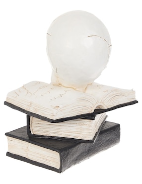Figura decorativa de halloween con forma de calavera sobre libros