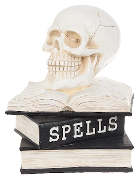 Figura decorativa de halloween con forma de calavera sobre libros