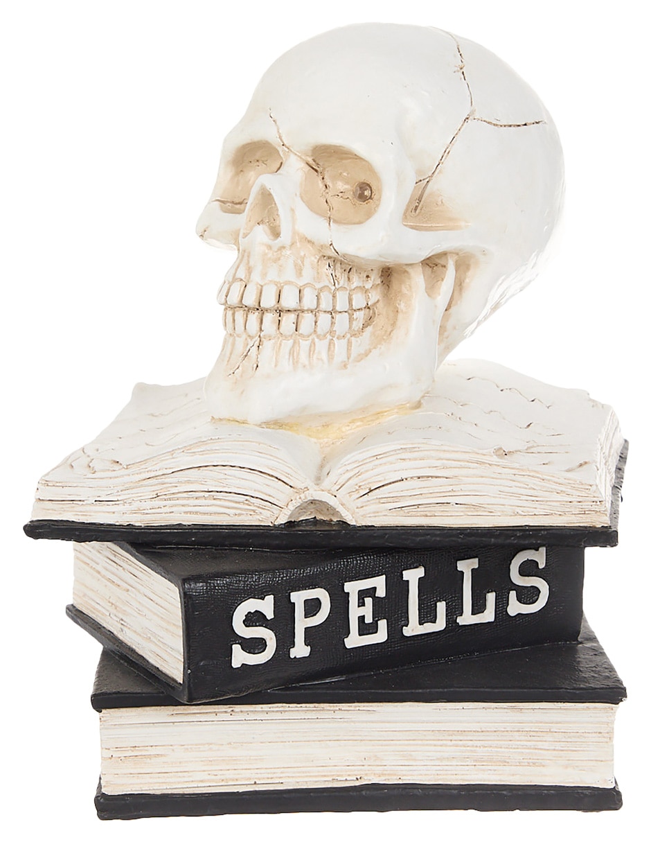 Figura decorativa de halloween con forma de calavera sobre libros 4